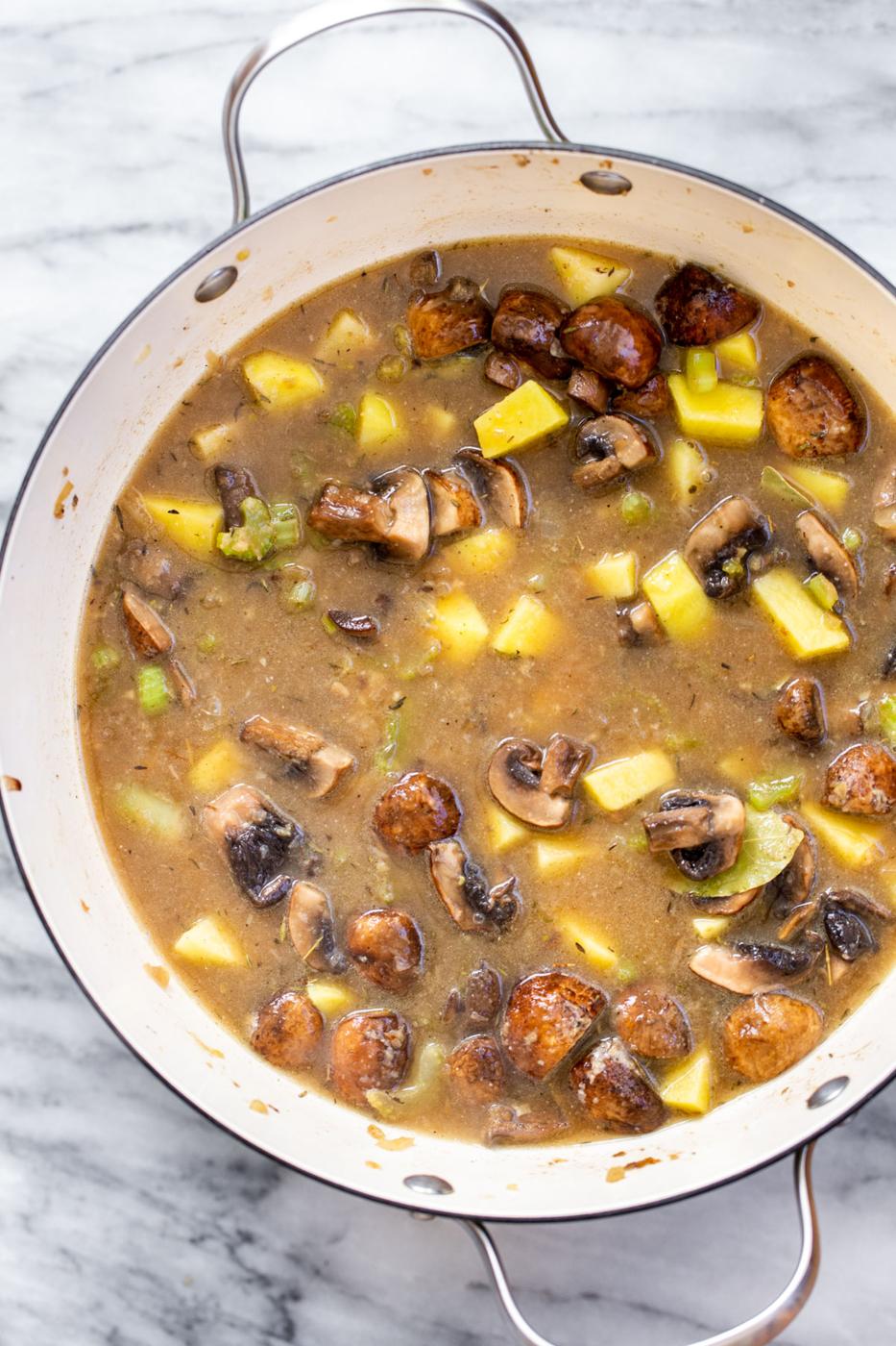 a pot with vegan mushroom chowder on a marble slate