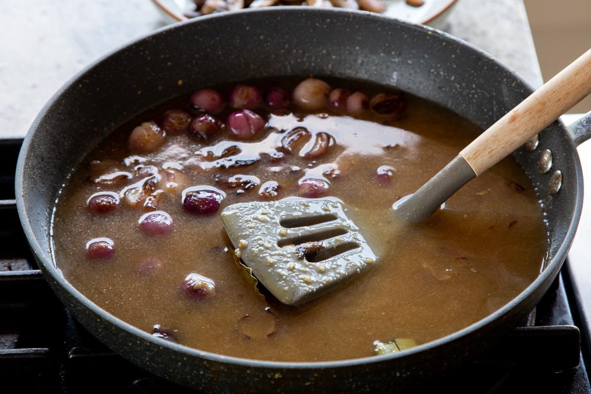 adding stock to the pan of onions, flour, and herbs