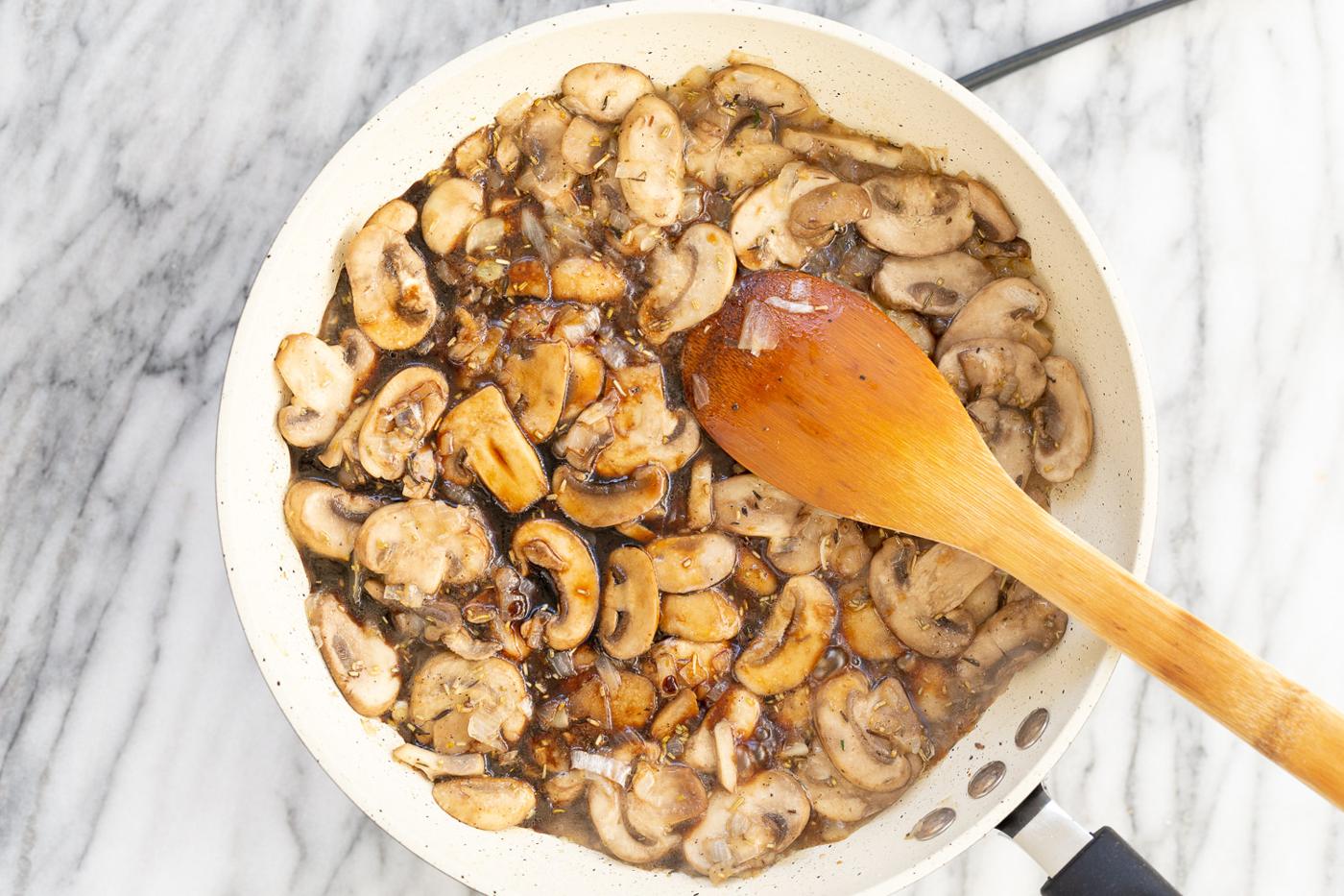 Mushrooms with sauces and herbs in a white skillet