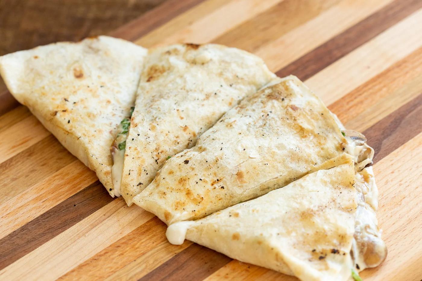 Grilled and sliced Vegan Mushroom Quesadilla on Wood board