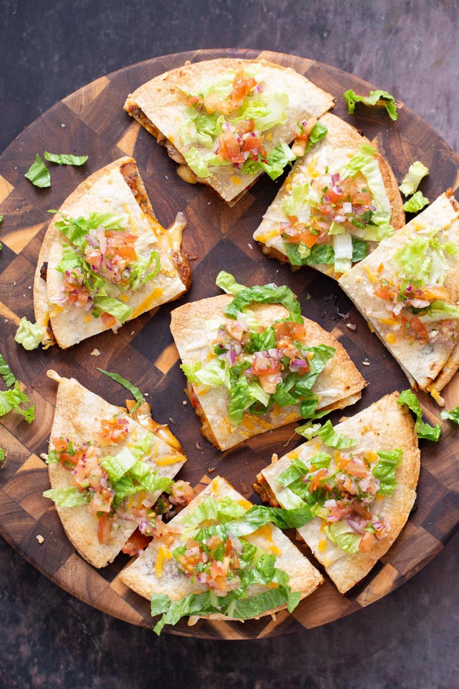 vegan mushroom tostadillas served topped with salsa and romaine on a wooden chopping board