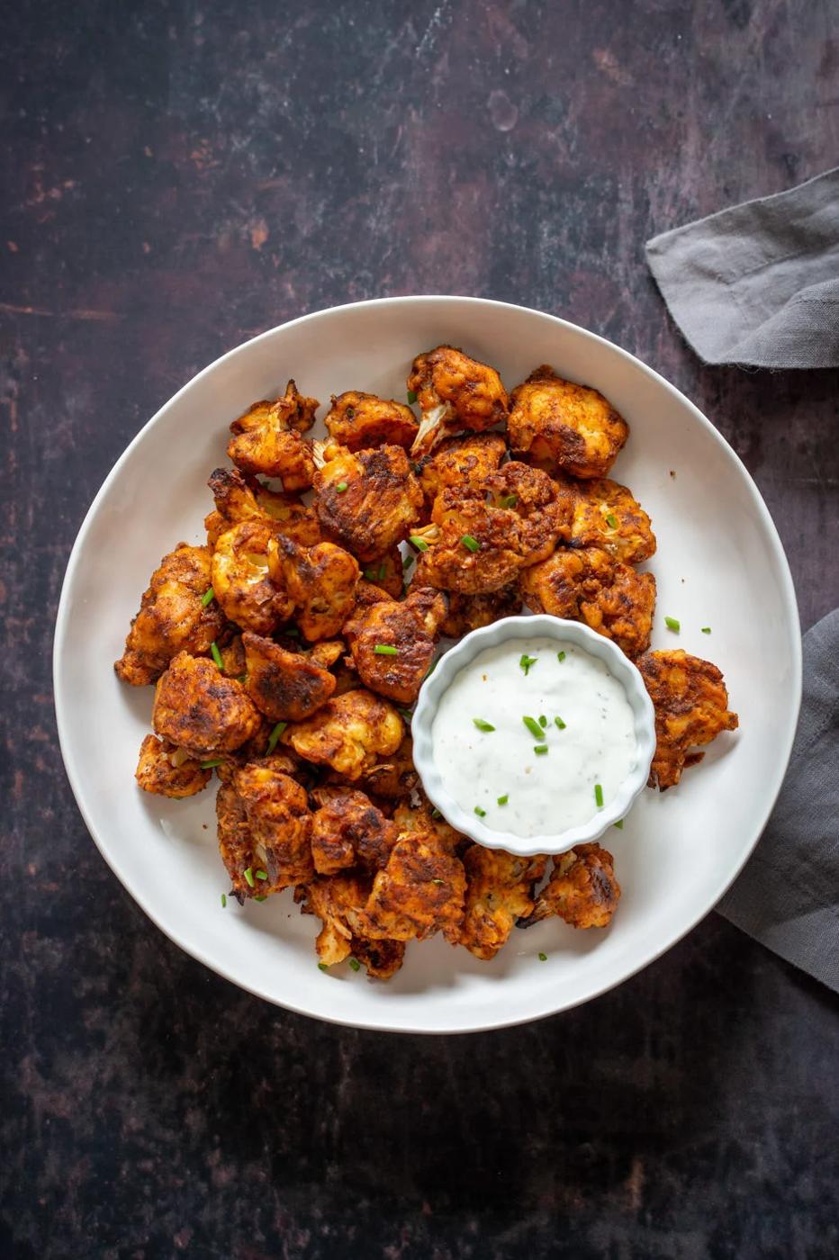 Vegan Nashville Hot Cauliflower Wings in a white bowl with vegan ranch