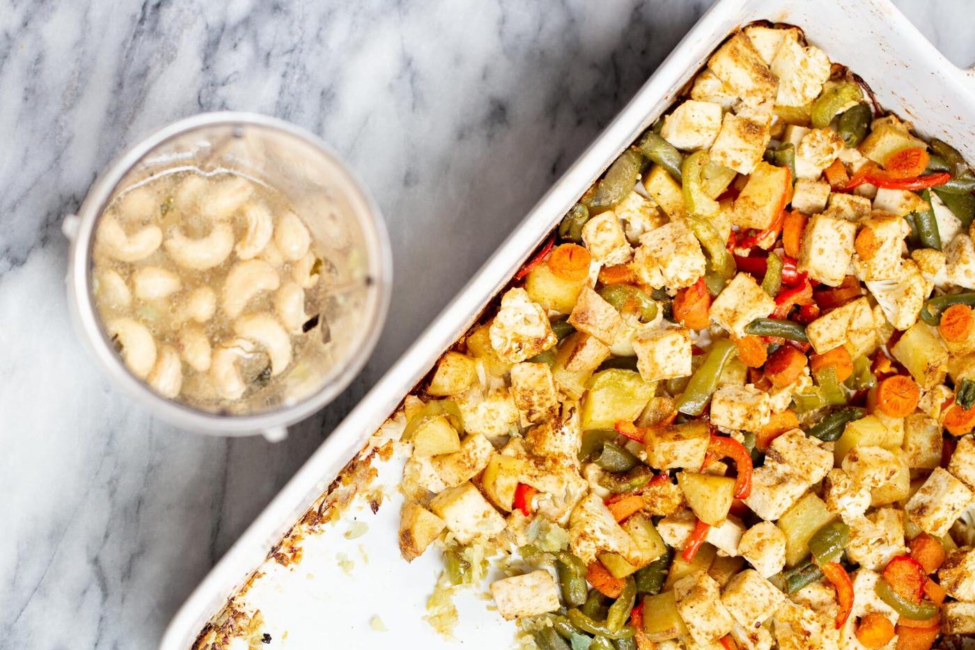soaked cashews next to a sheet pan with toasted tofu and veggies