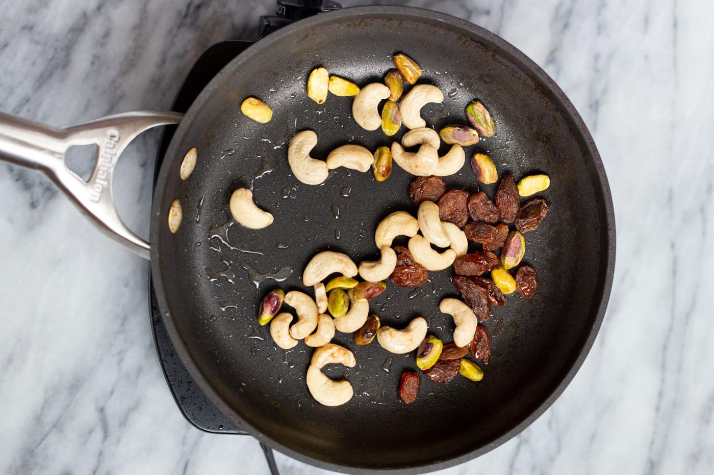 a black skillet with toasted nuts