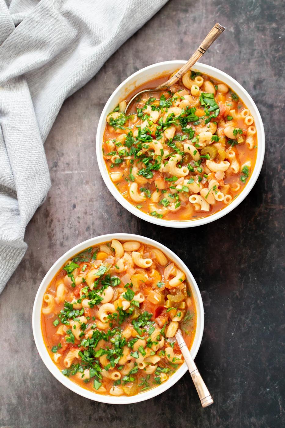 two bowls of vegan pasta e fagioli with spoons