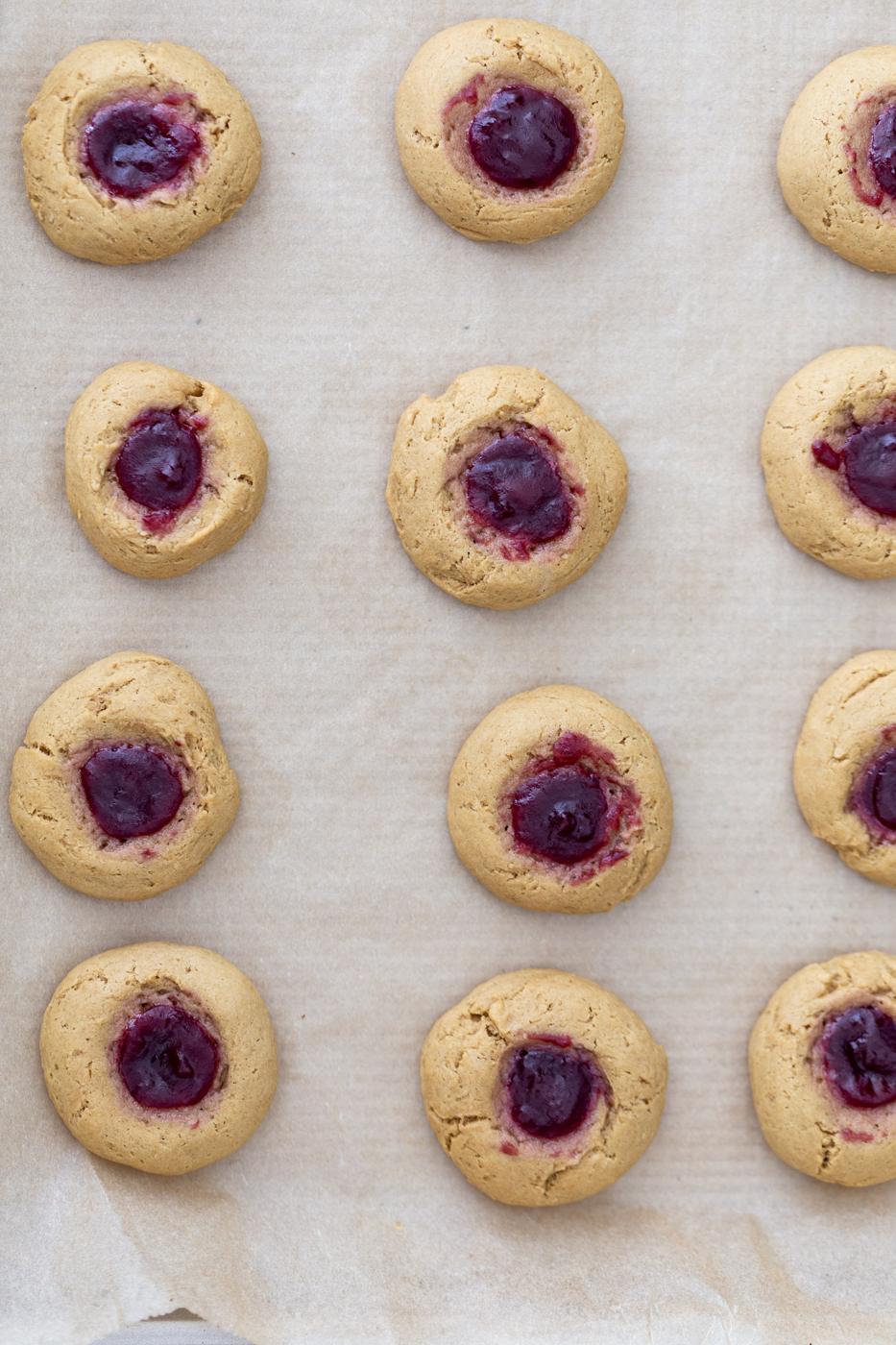 overhead shot of a cookie tray with freshly baked pb&j thumbprint cookies