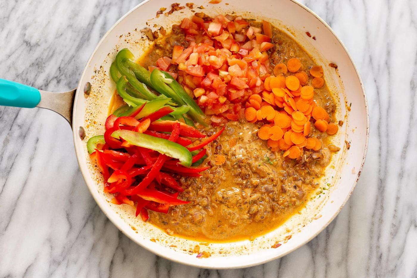 chopped vegetables being added to kidney bean peanut stew