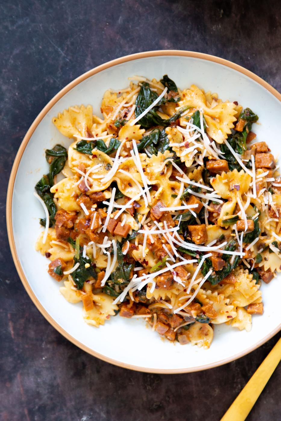 vegan pasta with vegan sausage, spinach and parmesan cheese