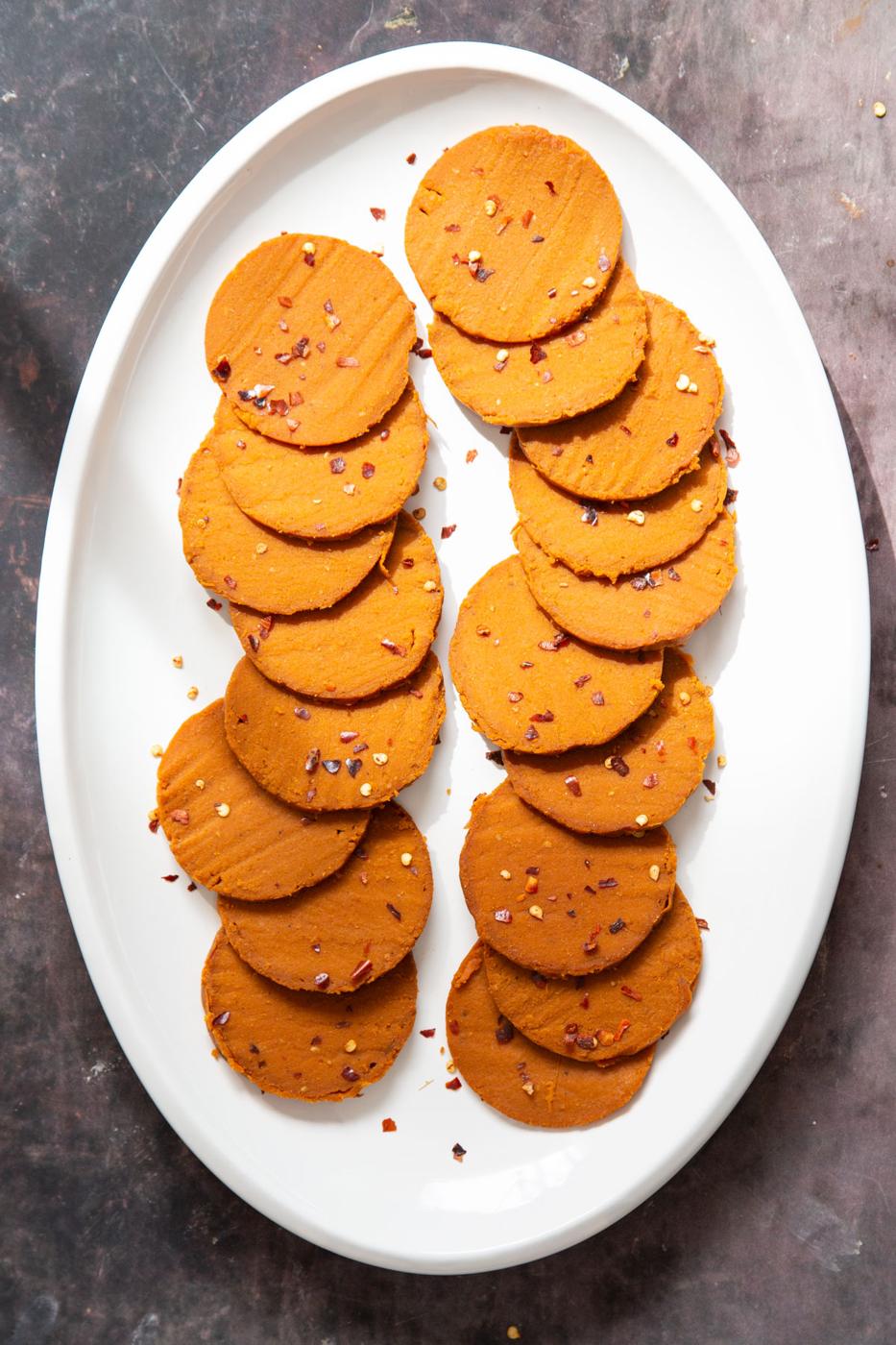 vegan pepperoni sausage sliced and layed out on an oval platter