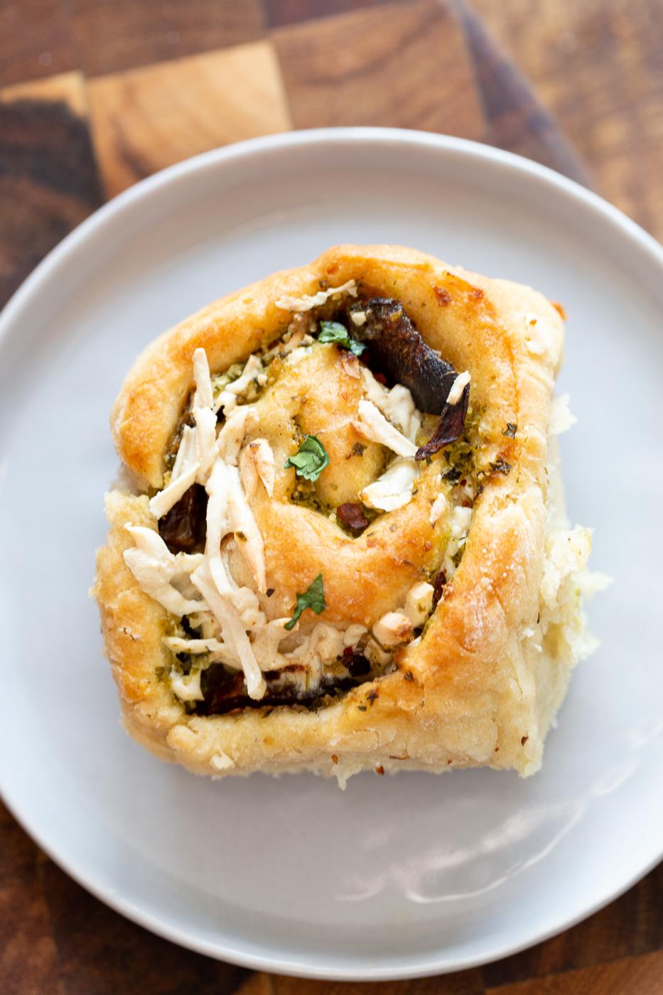 overhead shot of a vegan Pesto Pizza roll topped with vegan shredded mozzarella cheese