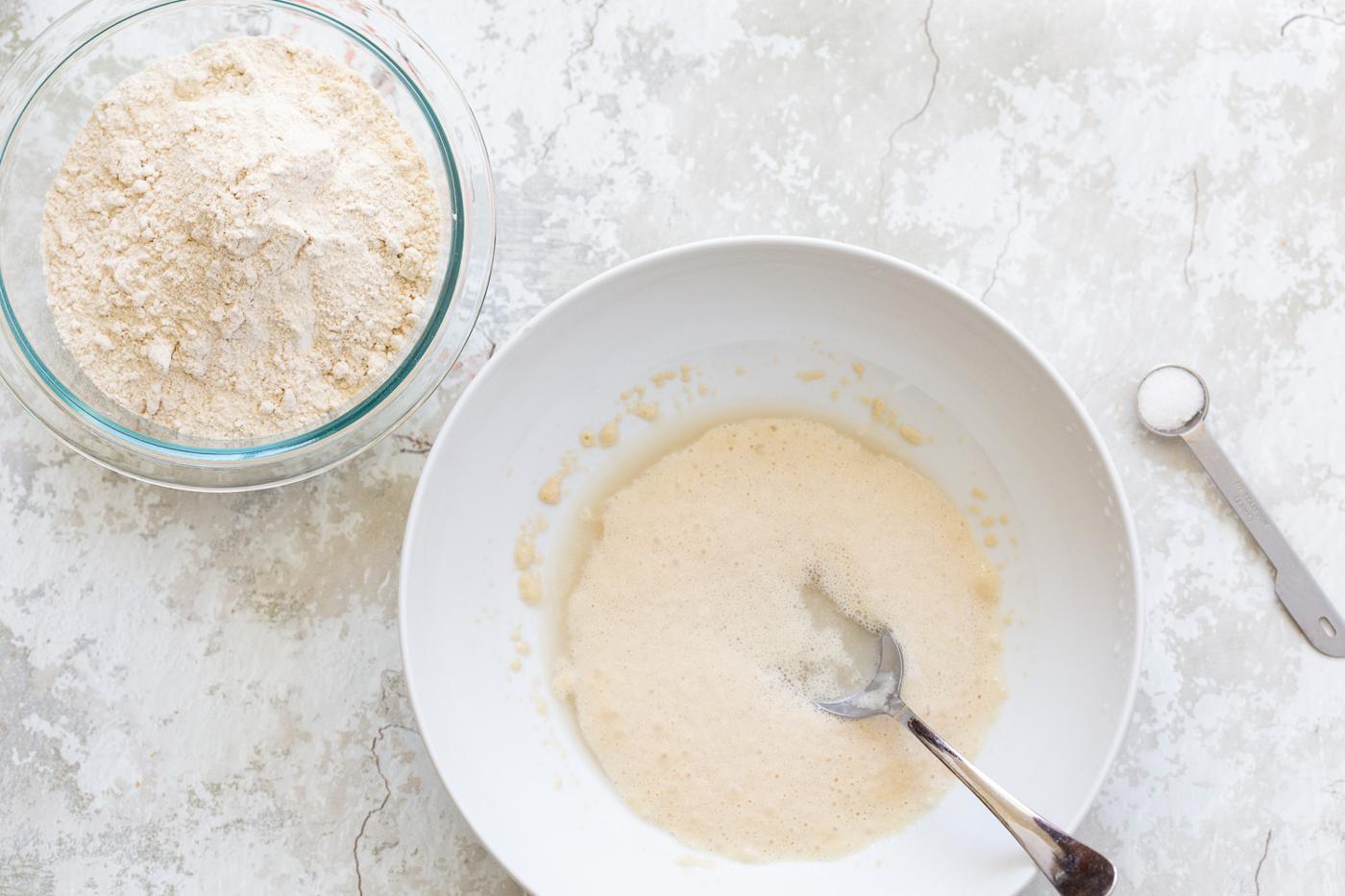water and yeast being stirred together to make pre-dough