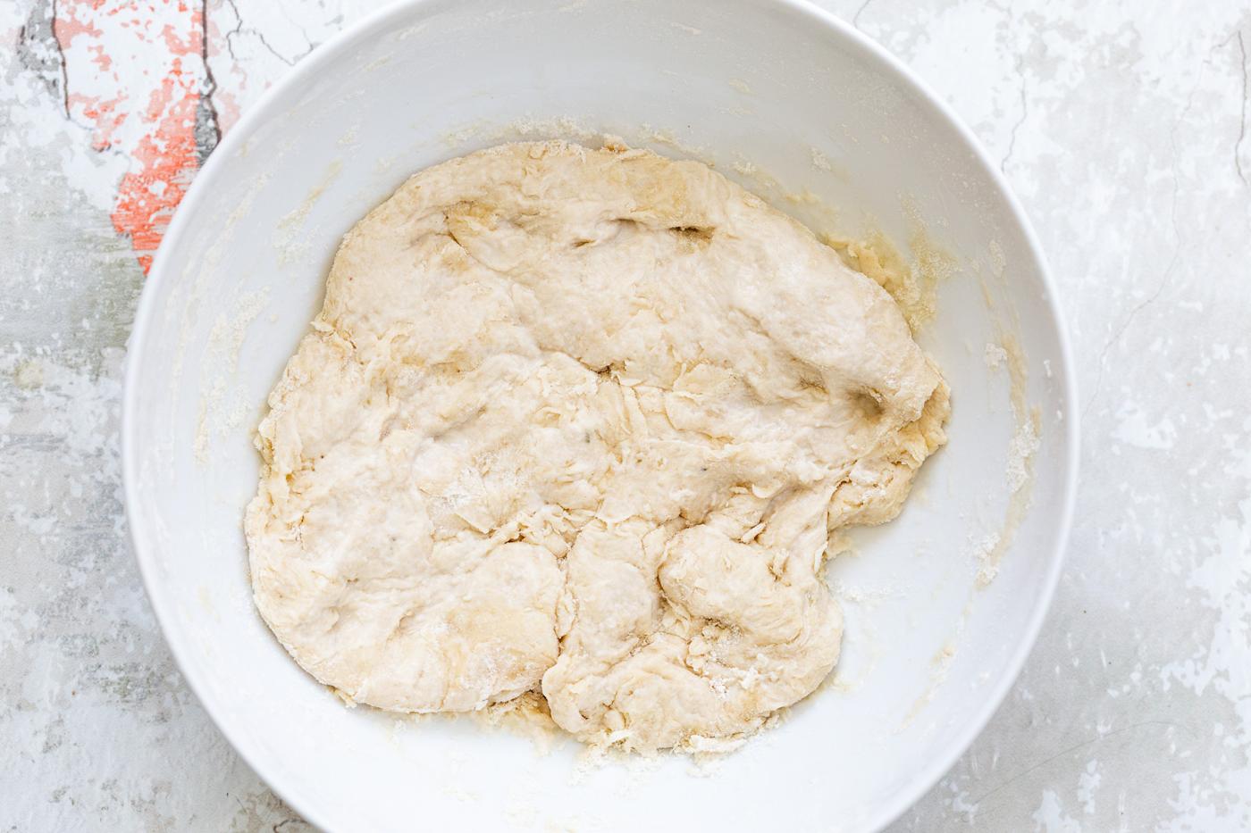pizza dough proofing in a bowl
