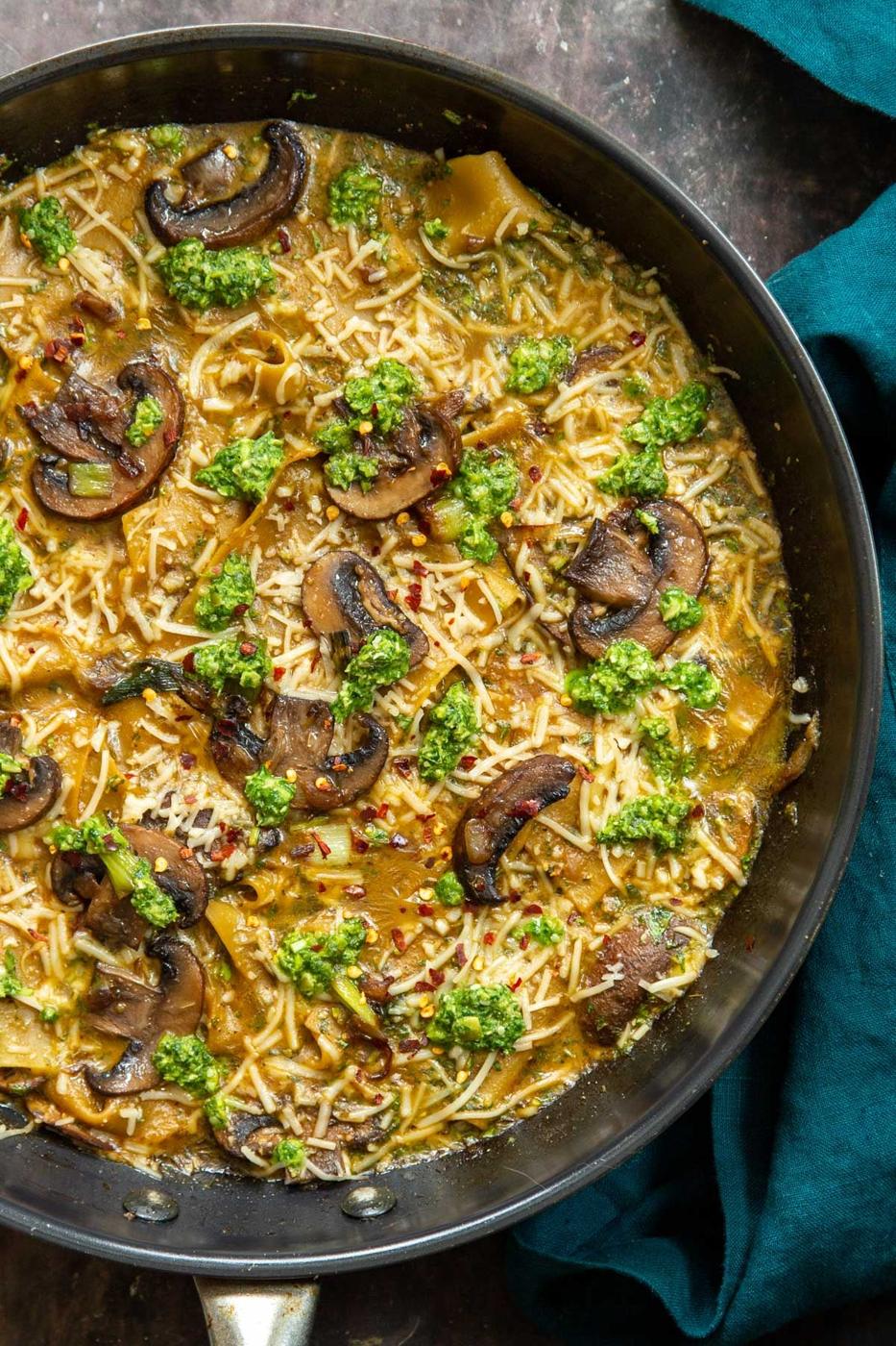 overhead shot of a black skillet with vegan one pan mushroom and pesto lasagna