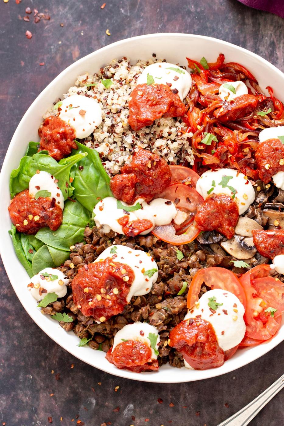 vegan quinoa bowls with pizza toppings like marinara, tomatoes and vegan cashew sauce