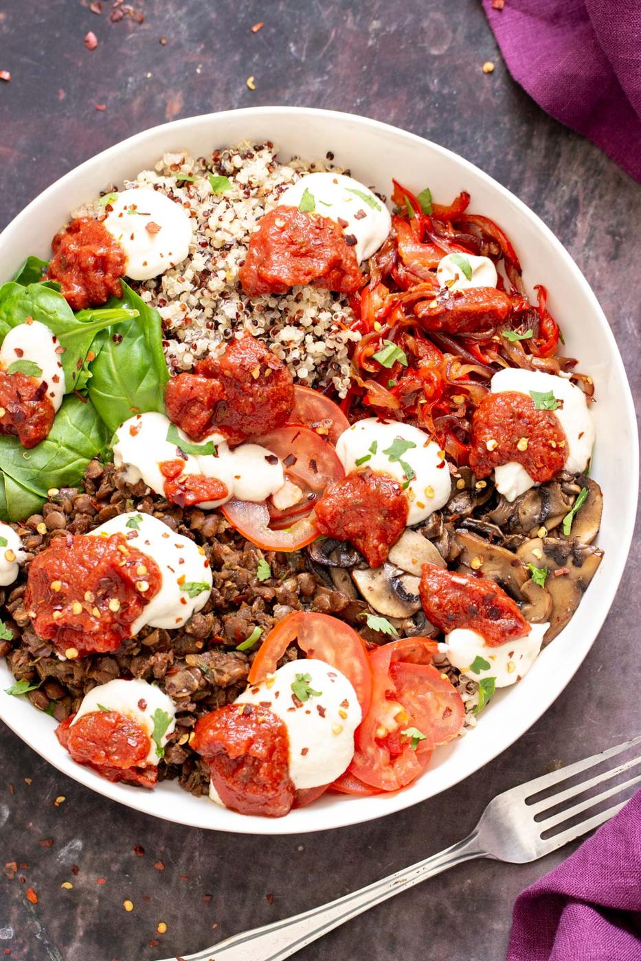 overhead shot of vegan quinoa pizza bowls with lentil sausage meat topped with vegan mozzarella cheese and marinara sauce