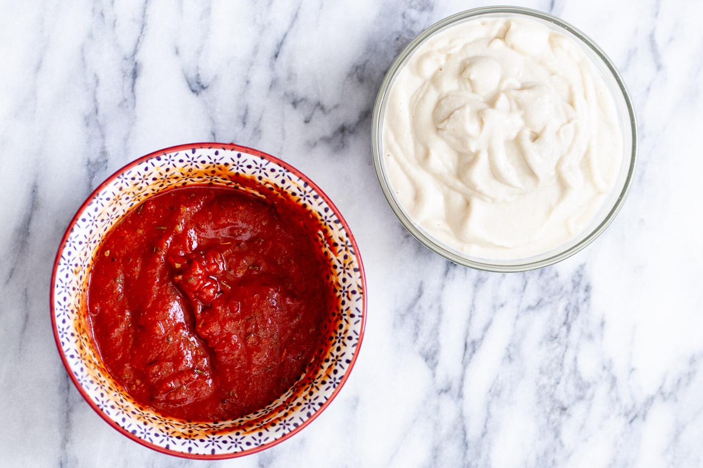 vegan cashew mozzarella sauce and pizza sauce in two bowls