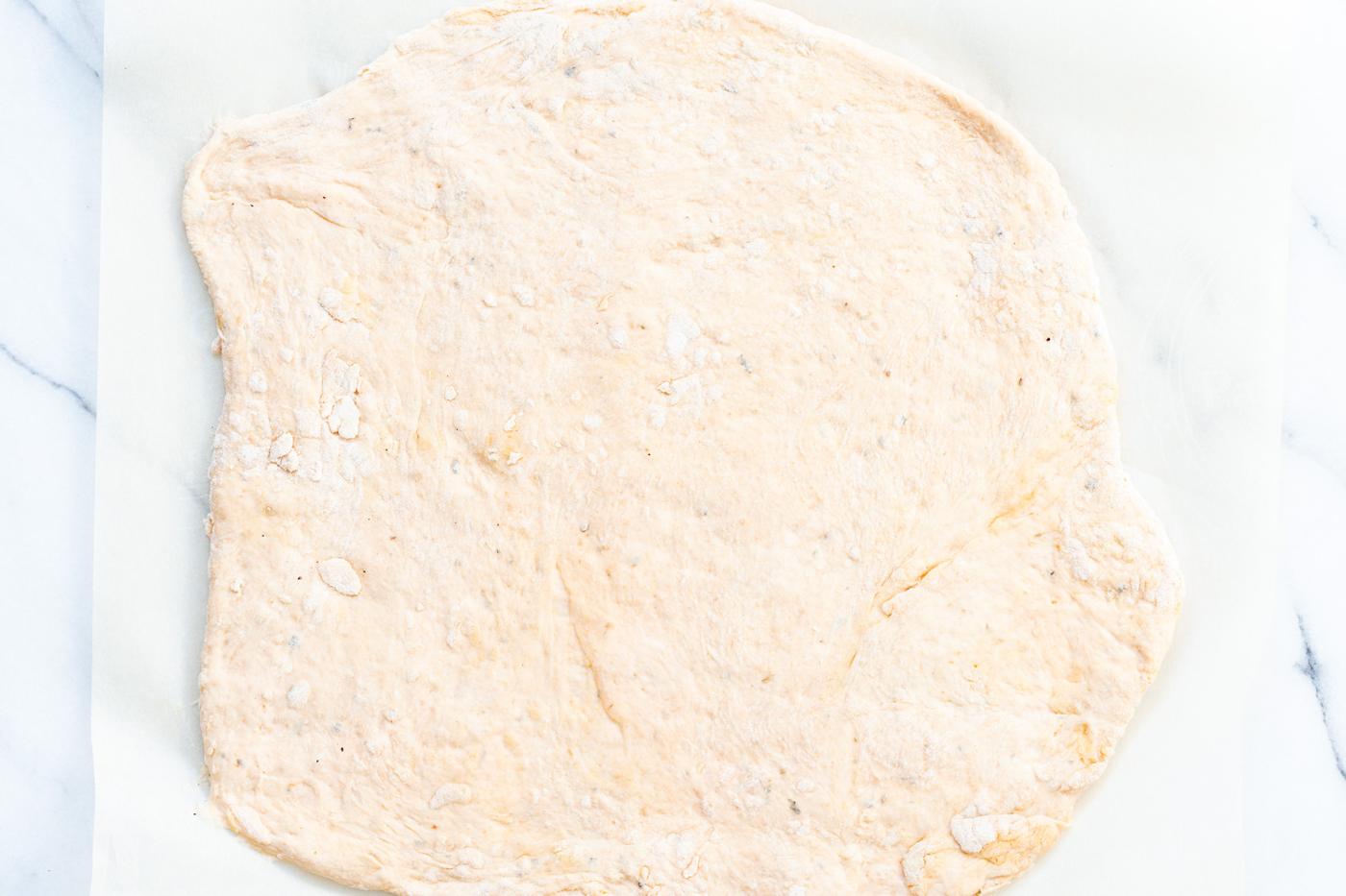 Vegan Pizza Rolls dough rolled out on parchment