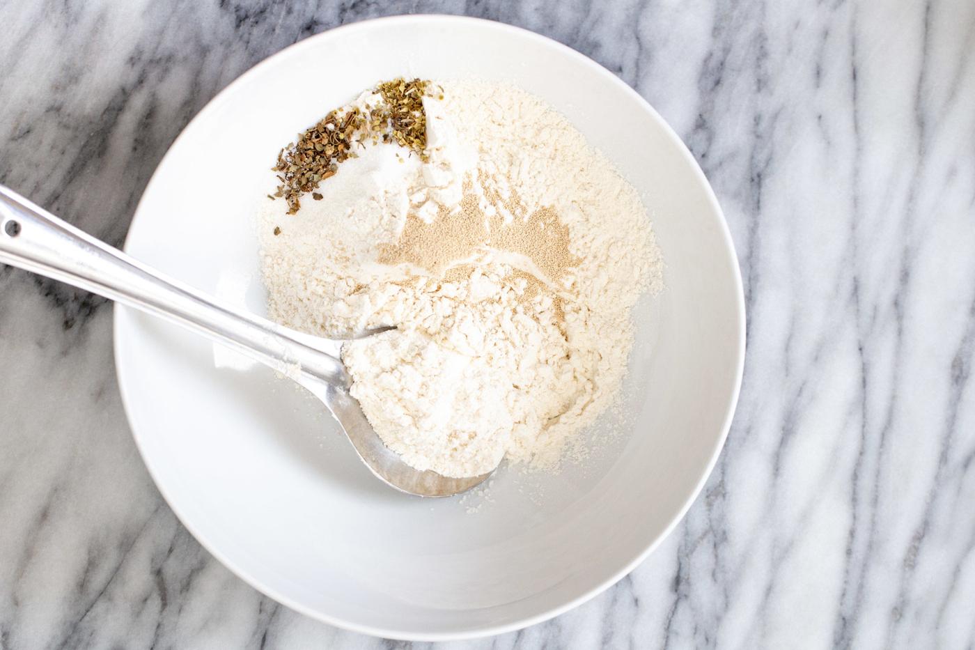 dry ingredients for making vegan pizza waffle batter in a white bowl