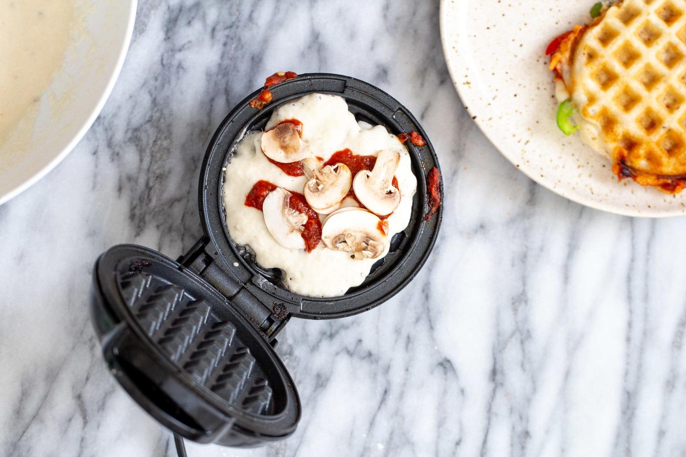 overhead shot of vegan pizza waffle batter topped with vegetables