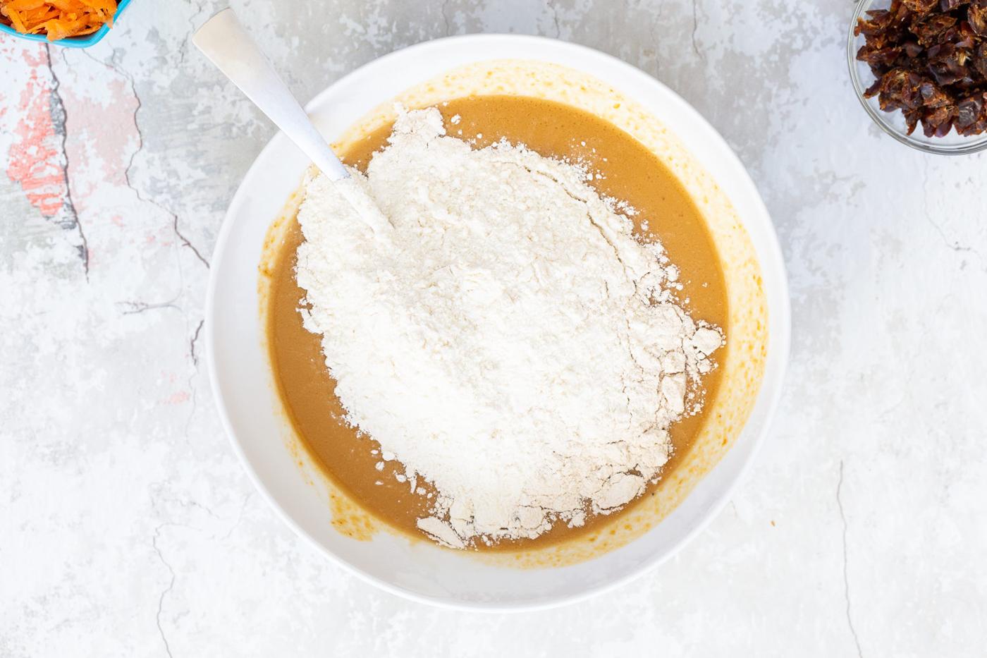 flour being added to vegan carrot pumpkin bread batter