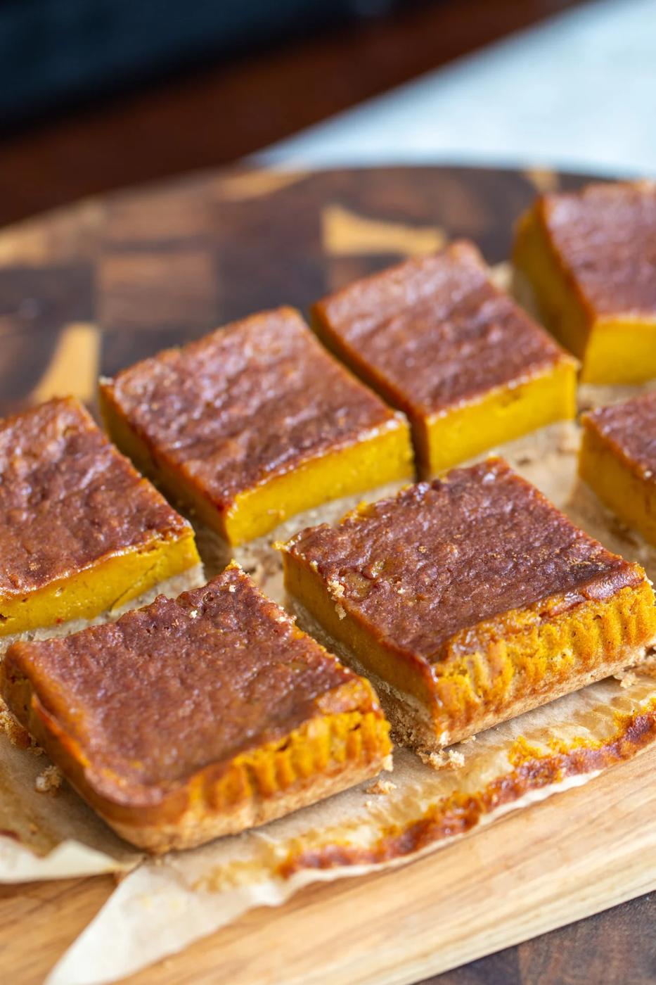 sliced vegan pumpkin pie bars arranged on a piece of parchment paper