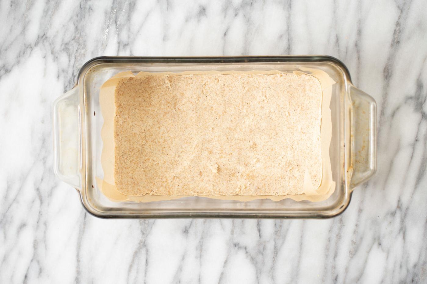 almond flour crust in a glass loaf pan