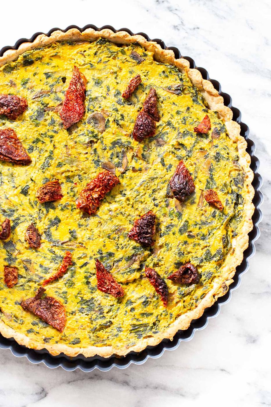 freshly baked vegan quiche with mushroom, spinach and leeks