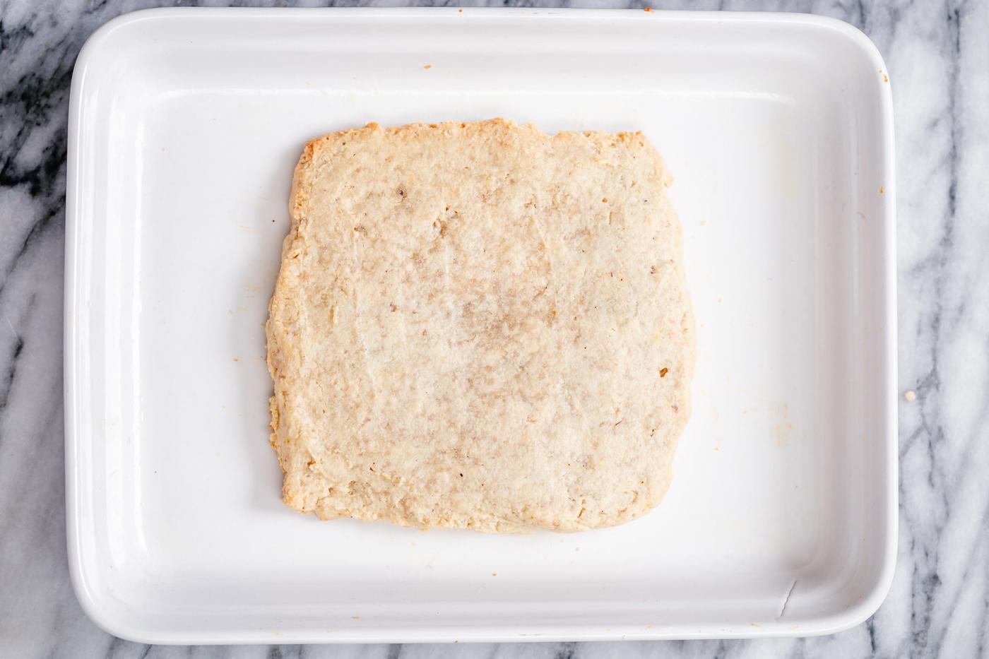 baked vegan rasmalai cake in a square baking pan