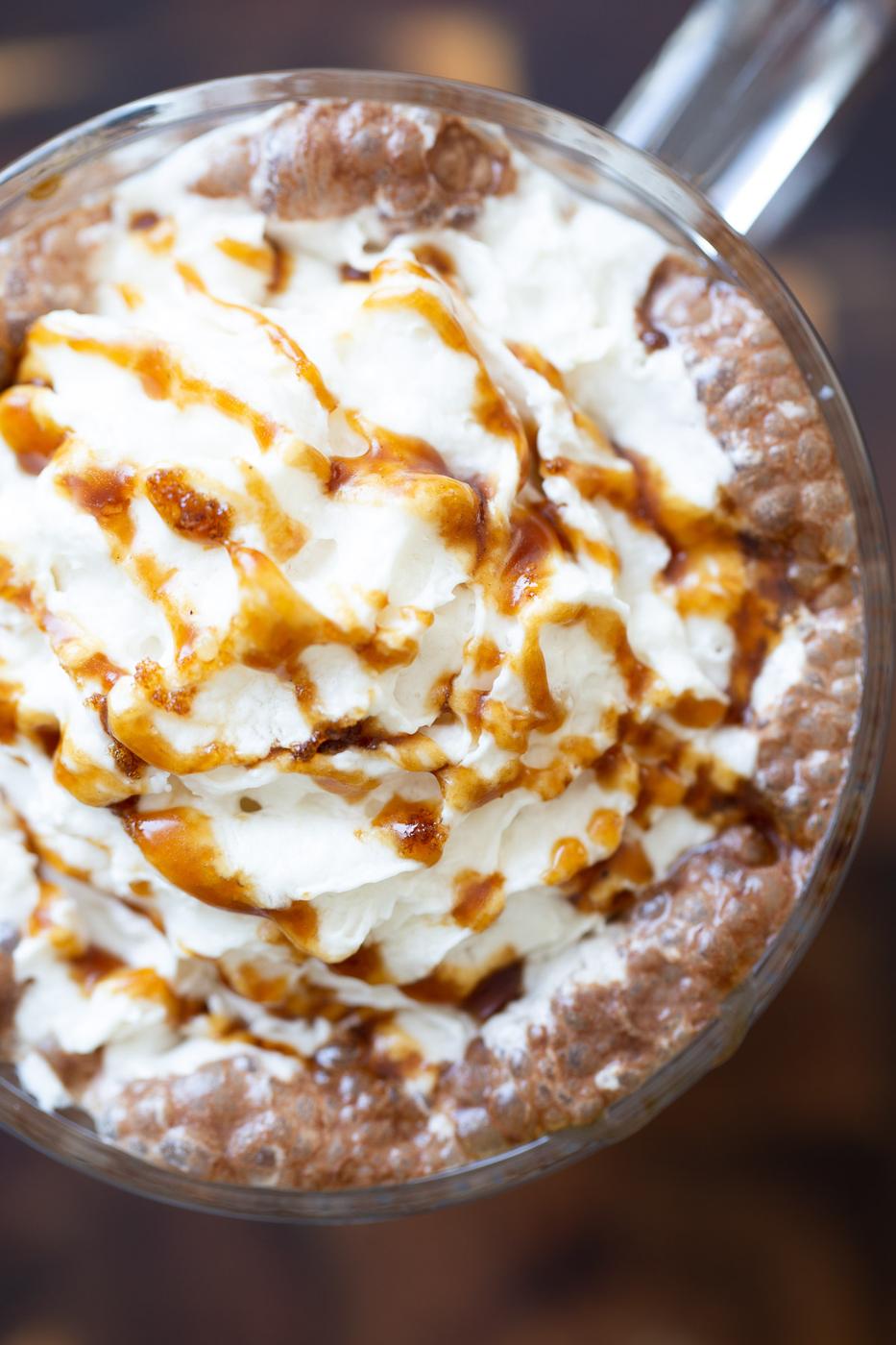 overhead shot of a mug of vegan salted caramel mocha topped with whipped coconut cream and caramel syrup