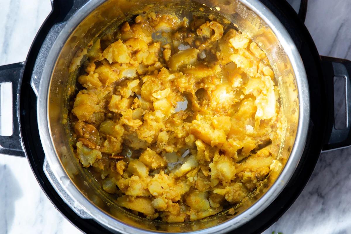 potatoes being mashed in an Instant Pot to make samosa filling