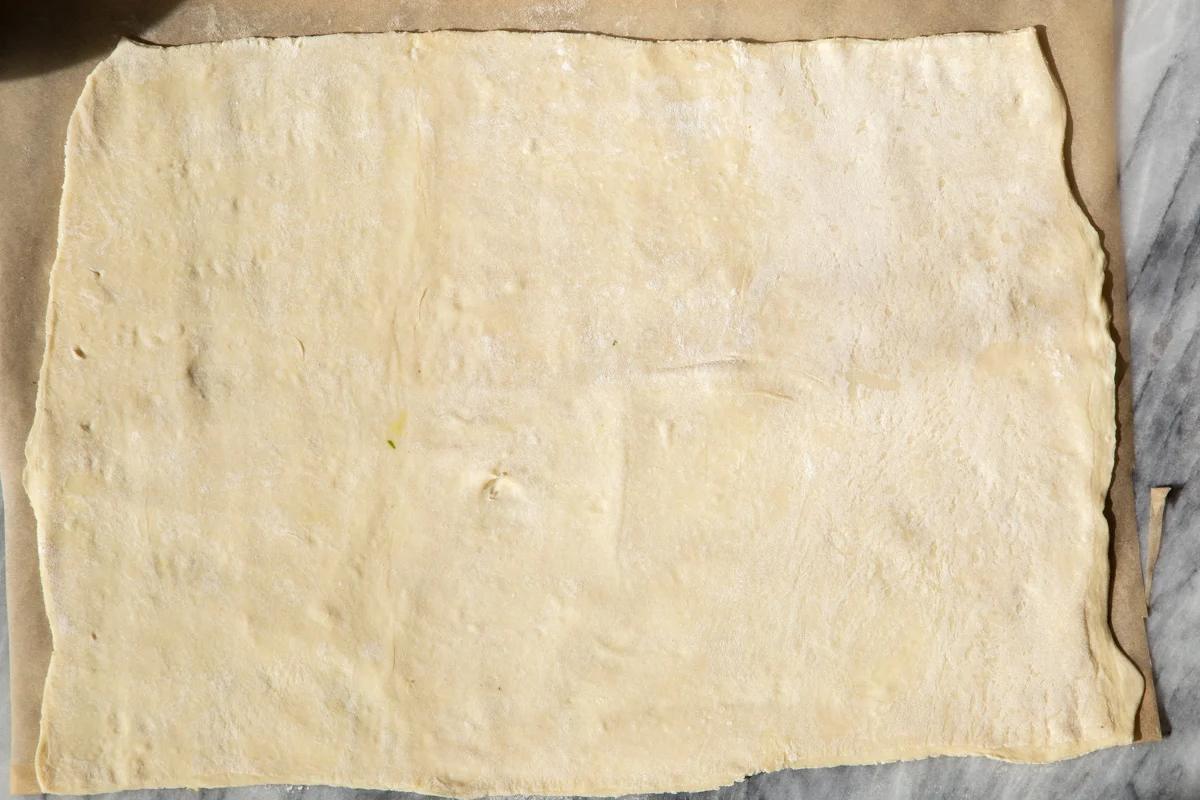 a thawed sheet of puff pastry on a marble counter