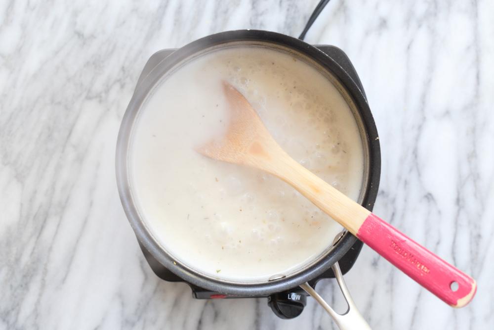 Scalloped potato creamy sauce mixture in a saucepan