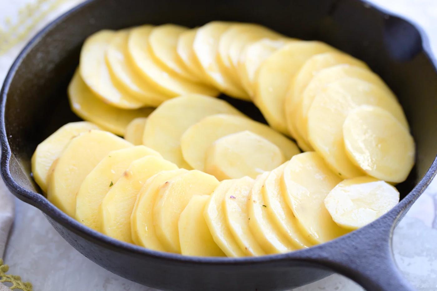 sliced potatoes in a cast iron skillet