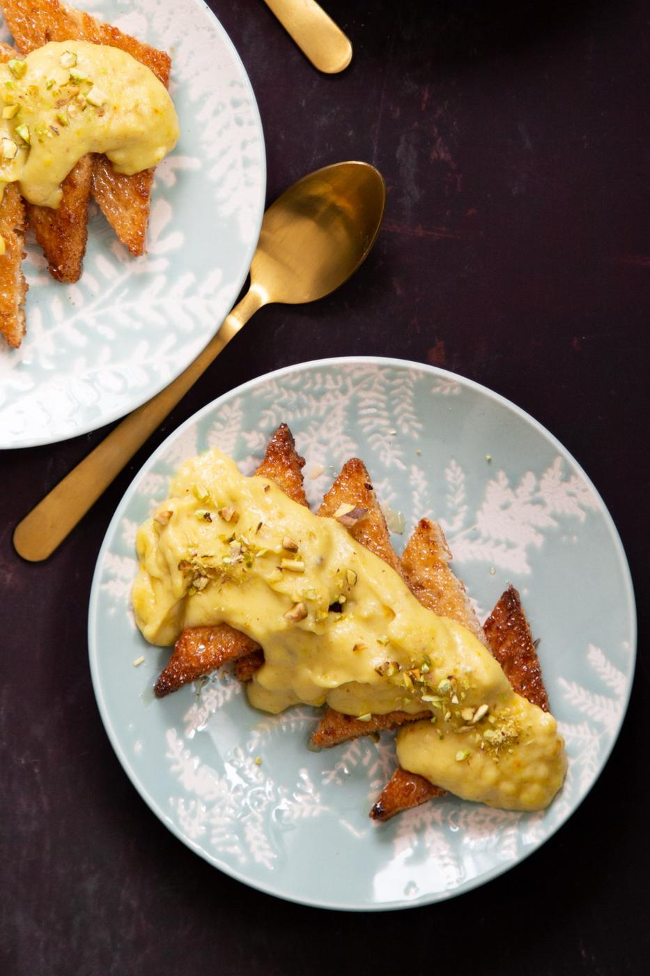 sliced Shahi Tukda brushed with cardamom syrup and topped with custard and sprinkled with pistachio
