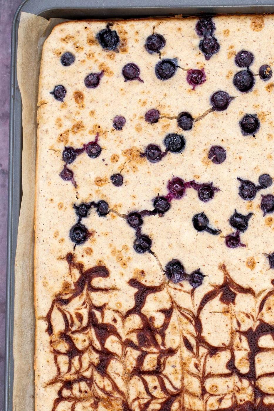freshly baked vegan sheet pan pancakes with cinnamon swirl and blueberries