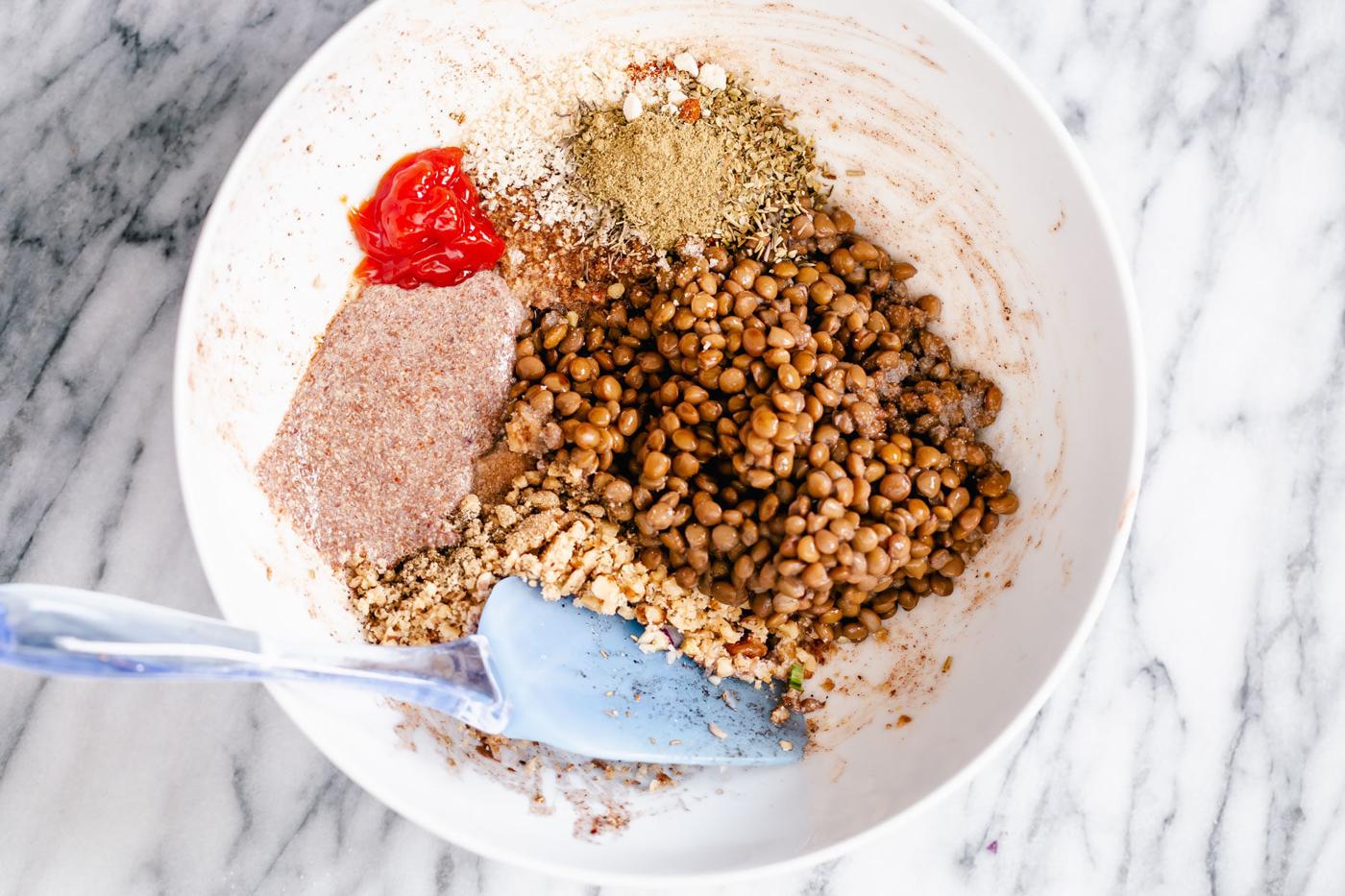 lentil meatloaf mixture being tossed in a white bowl