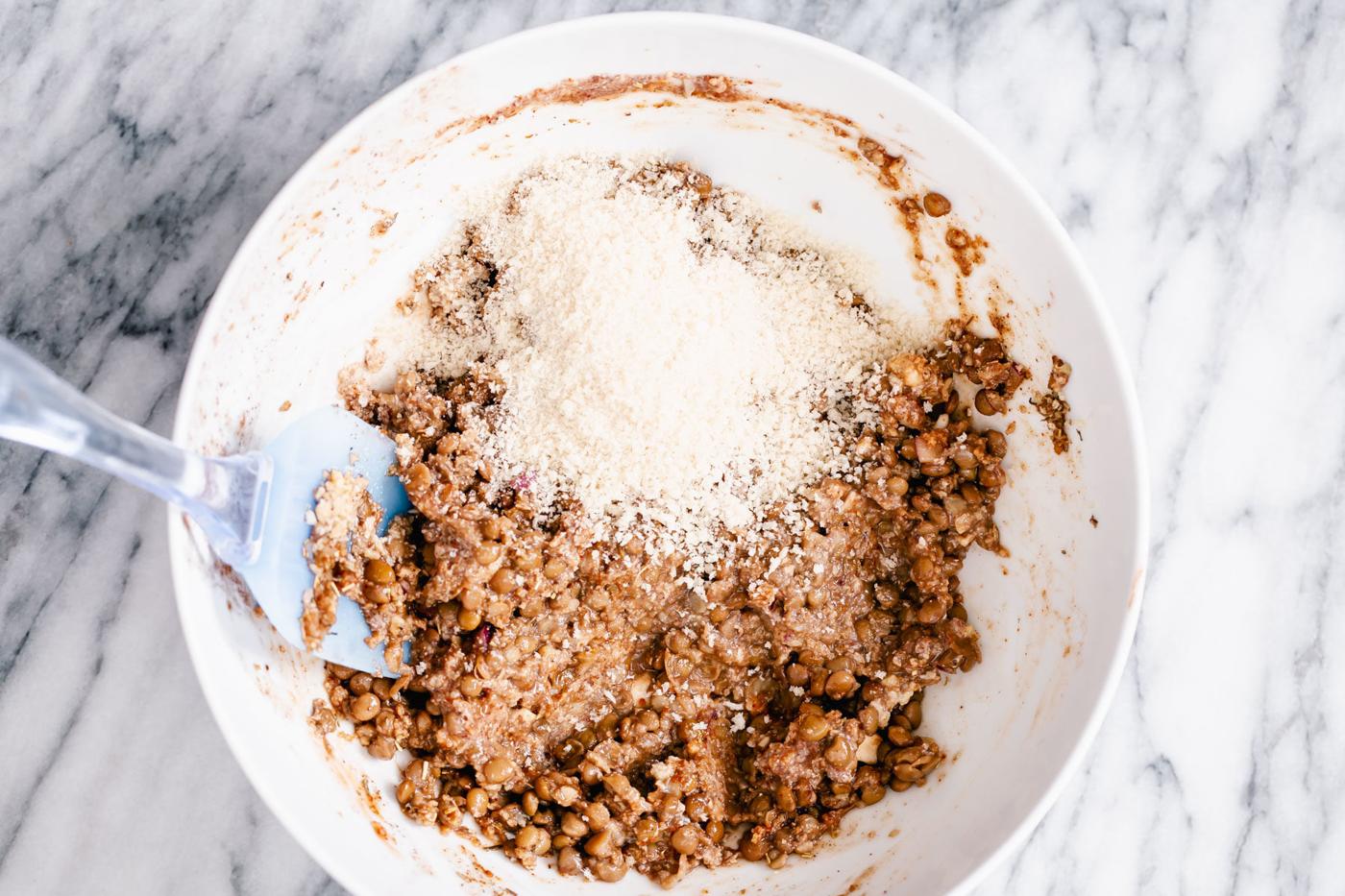 ingredients for vegan meatloaf being mixed in a white bowl