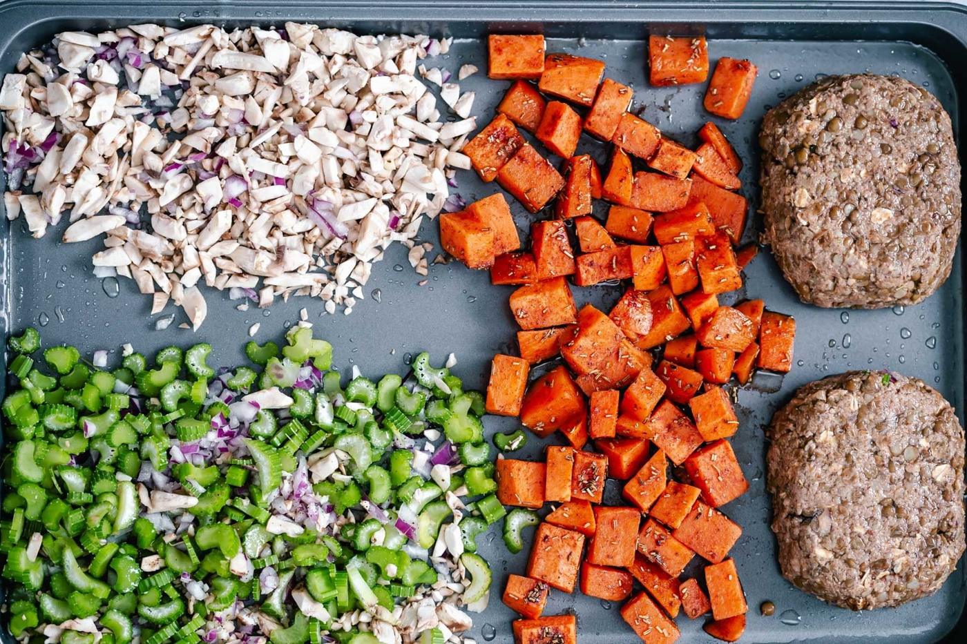overhead shot of vegan lentil loaves being placed on a baking sheet with side dishes
