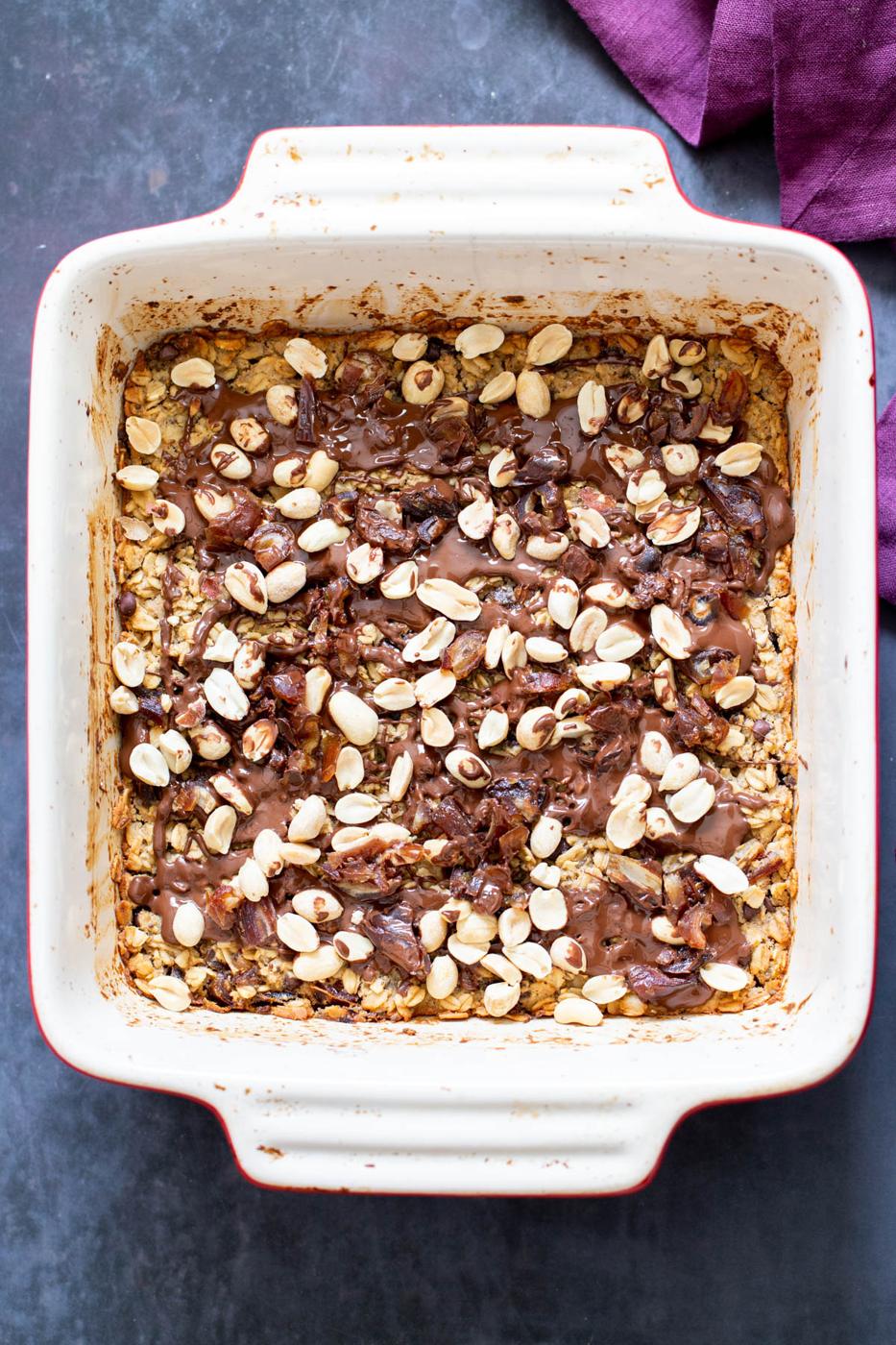 a casserole dish with vegan snickers baked oatmeal
