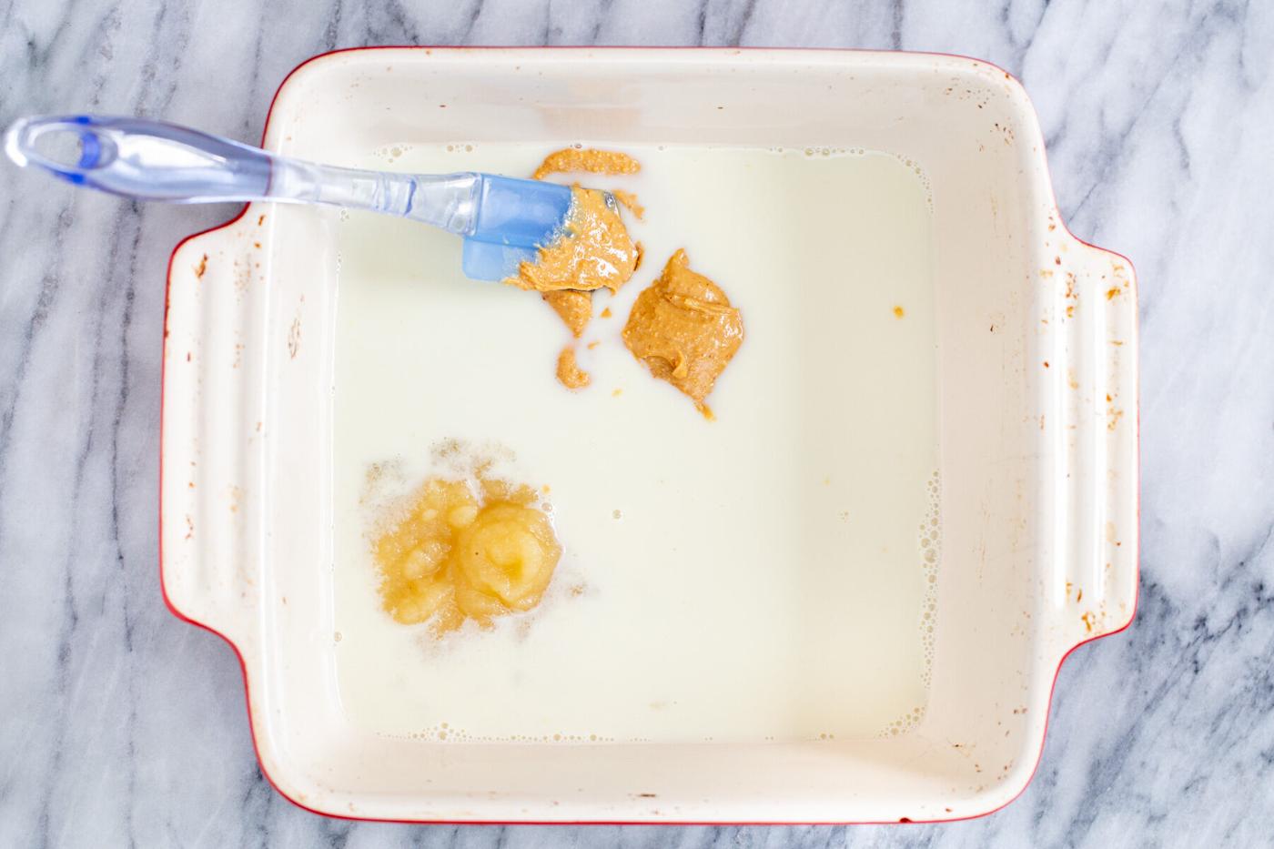 a casserole dish with applesauce, peanut butter and hot milk