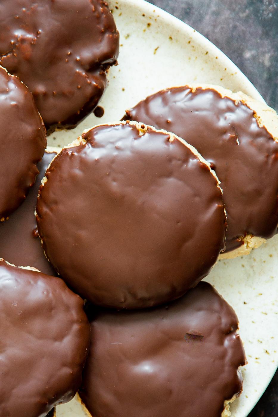 a white plate with vegan snickers cookies covered with chocolate glaze