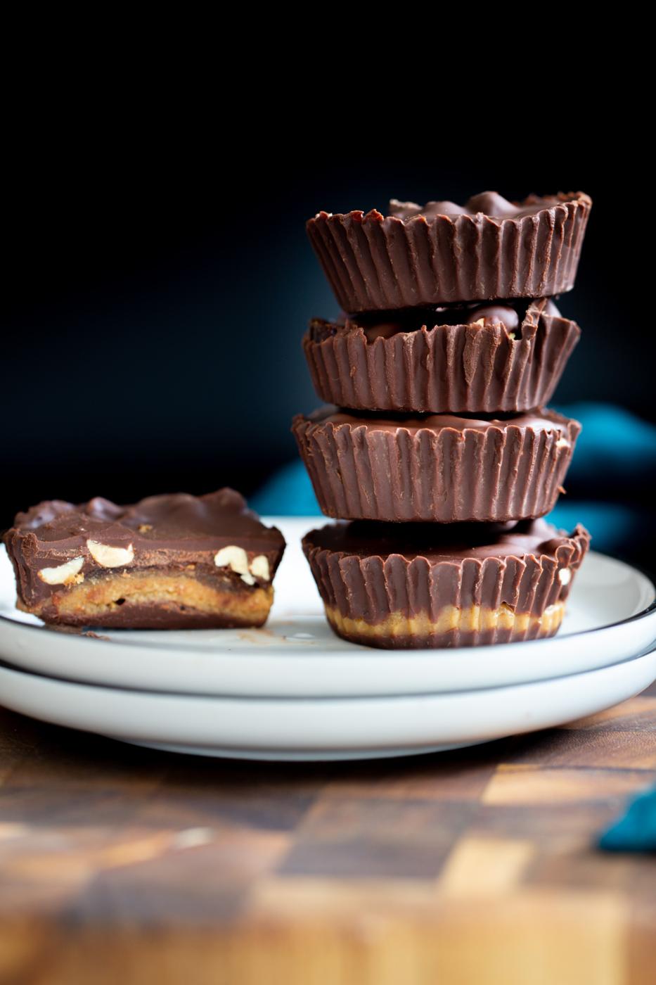 vegan peanut butter snickers cups with dates against a black background