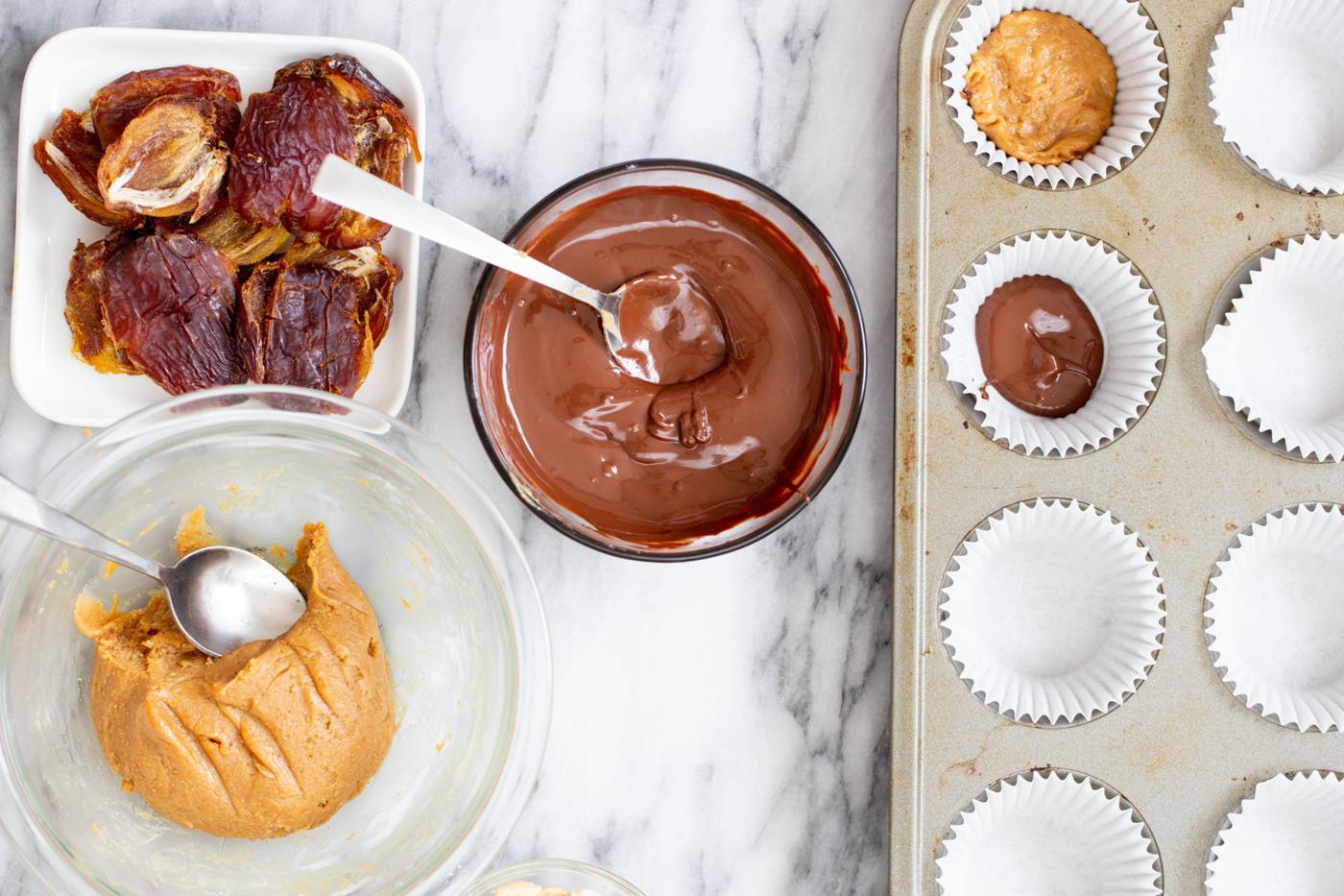 peanut butter being added to melted chocolate to make peanut butter cups