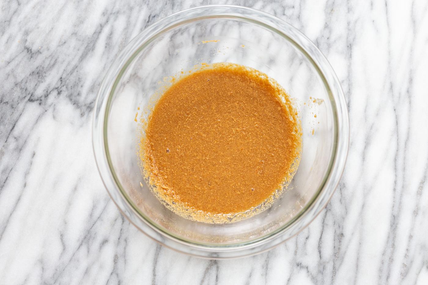 melted peanut butter heated with plant-based milk in a small glass bowl