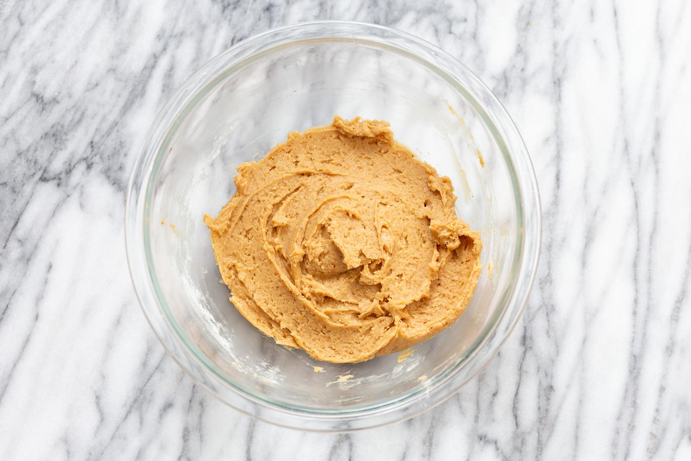 cookie batter for vegan snickers bars recipe in a glass bowl