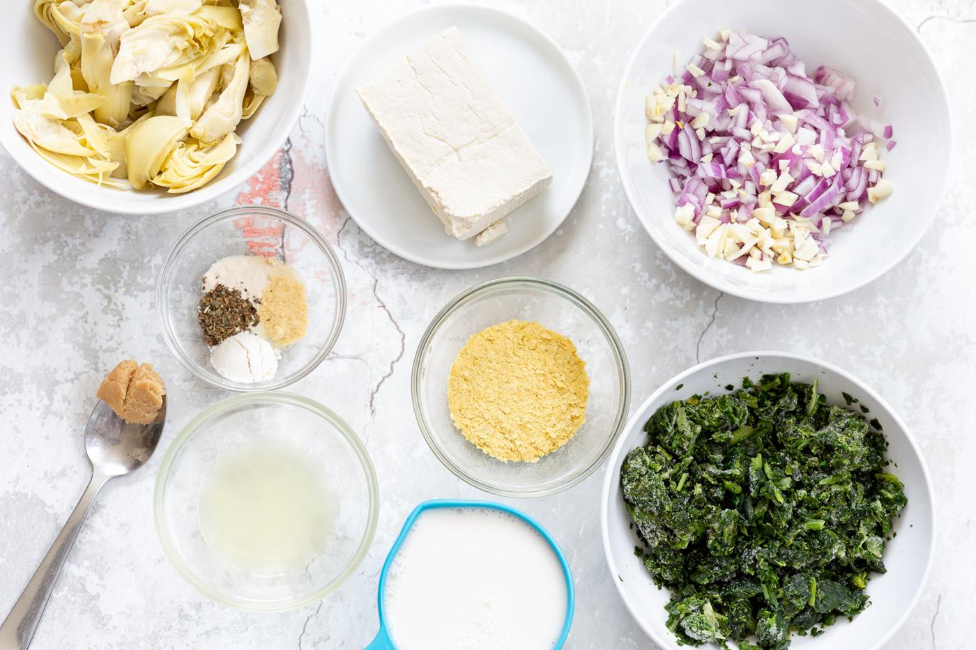 overhead shot of ingredients needed for making spinach artichoke pasta bake