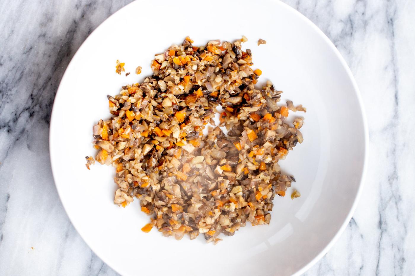 sauteed mushrooms and carrots in a sauteeing pan