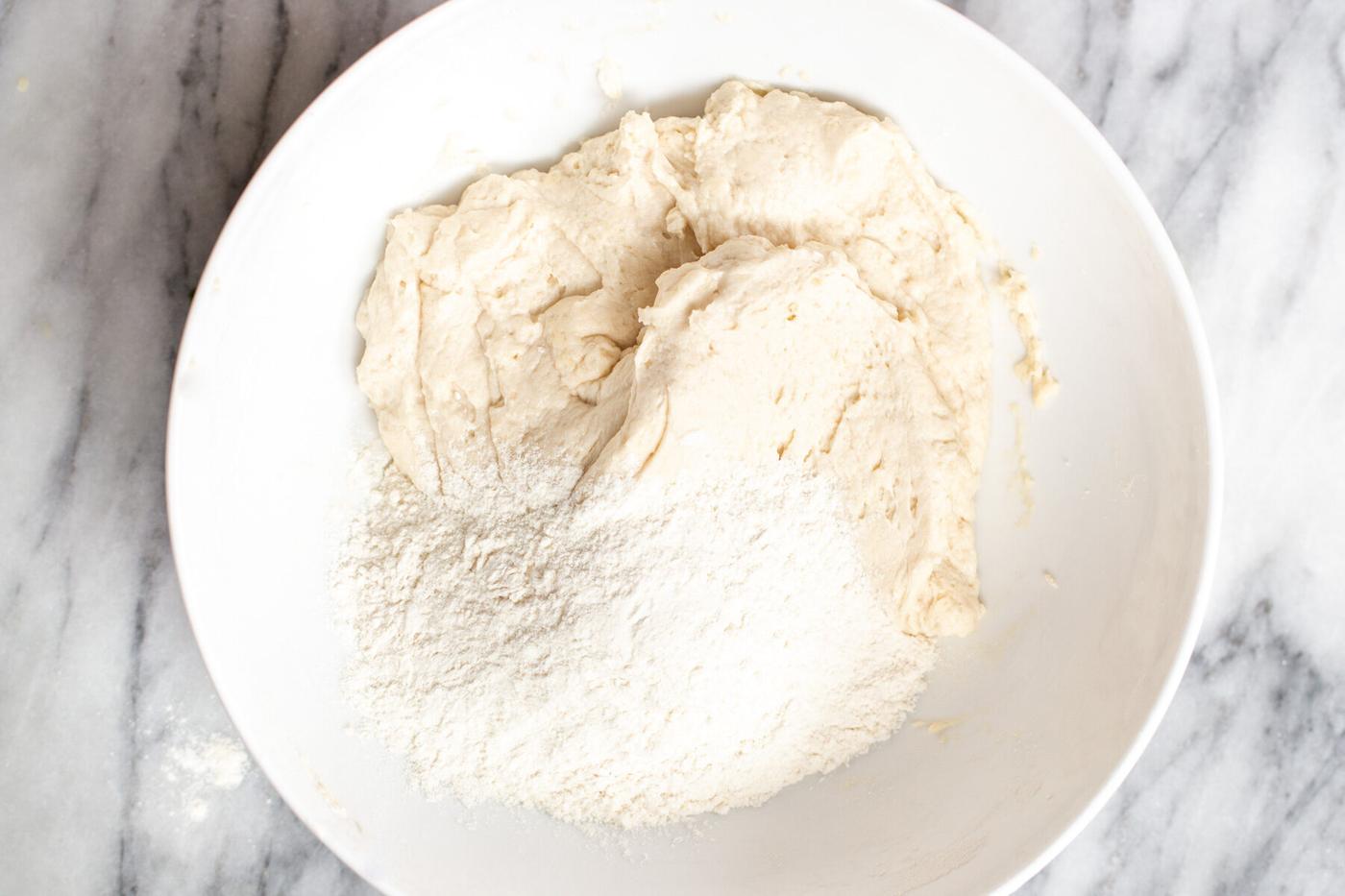 vegan naan bread dough being prepared in a white bowl