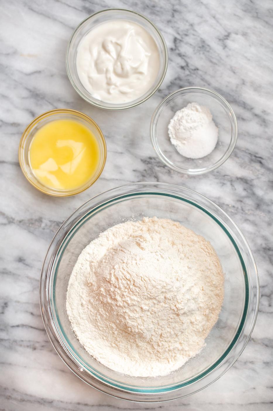 ingredients for naan bread dough on a marble counter