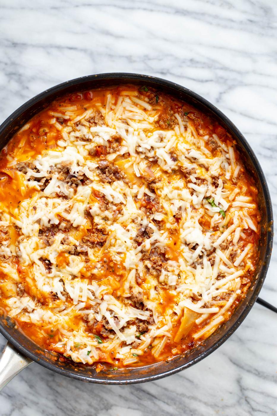 vegan skillet lasagna with vegan cheese shreds in a black iron skillet